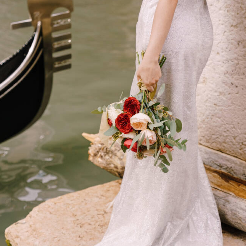 Sposa con bouquet in mano che attende di salire sulla gondola 